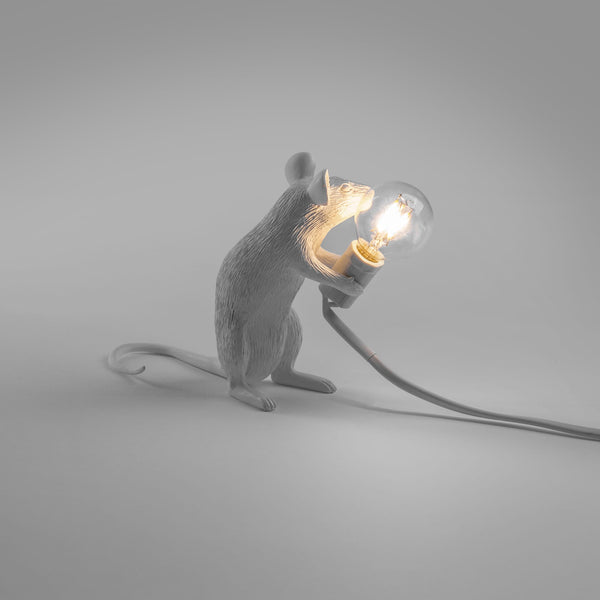 stehende weiße Maus mit Glühbirne in der Hand