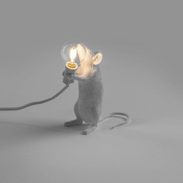 stehende weiße Mauslampe mit leuchtender Glühbirne in der Hand