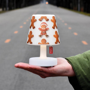 Fatboy-Lampe Edison the Petit in Mini-Version inklusive Cooper-Cappie in Lebkuchenoptik. Wird auf einer Hand gehalten. Im Hintergrund ist die Allee im Prater zu sehen. 