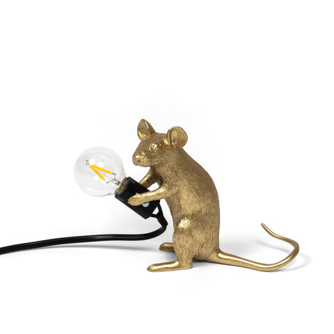 Sitzende goldene Maus mit Glühbirne in der Hand