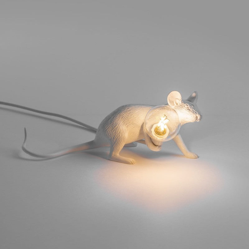 sitzende weiße Mauslampe mit leuchtender Glühbirne in der Hand