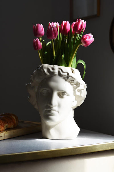 Kopf des Gott Apollo als Vase, in weiß glänzend, mit Tulpen gefüllt 