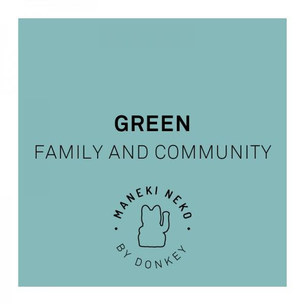 Die Winkekatze in Grün steht für Familie und Gemeinschaft.